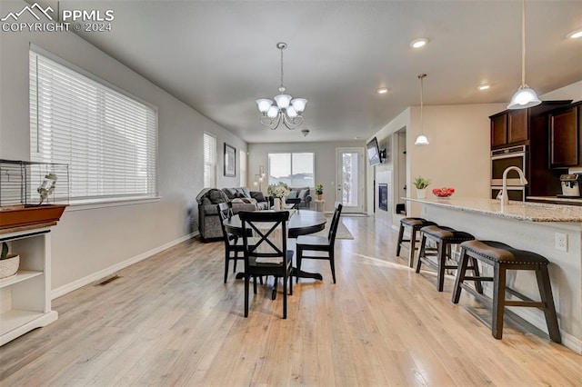 dining area featuring a chandelier and light hardwood / wood-style flooring