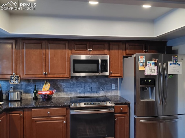 kitchen with decorative backsplash, dark stone counters, and appliances with stainless steel finishes