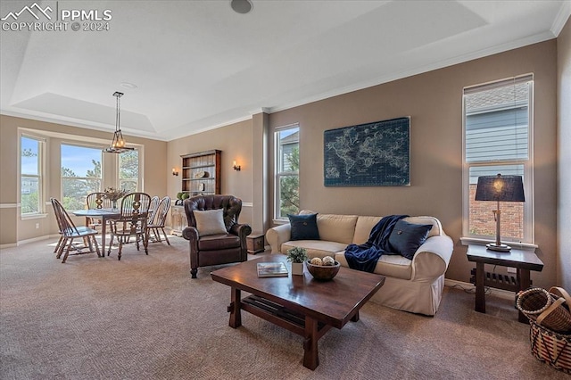 carpeted living room with a tray ceiling and crown molding