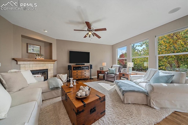 living room featuring a fireplace, hardwood / wood-style flooring, and ceiling fan