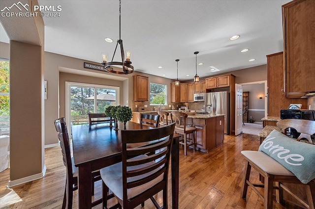 dining space featuring hardwood / wood-style flooring and an inviting chandelier