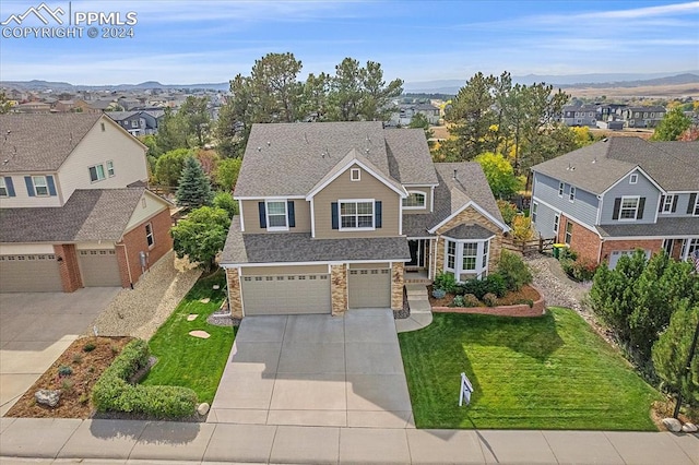 view of front facade with a mountain view, a garage, and a front lawn