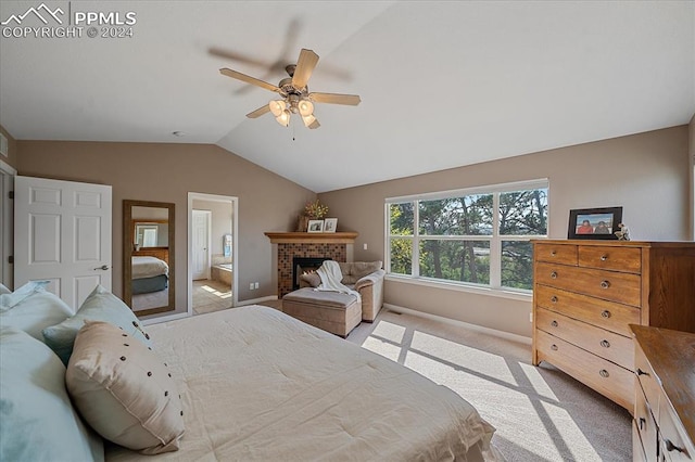 bedroom featuring lofted ceiling, ceiling fan, a fireplace, ensuite bath, and light colored carpet