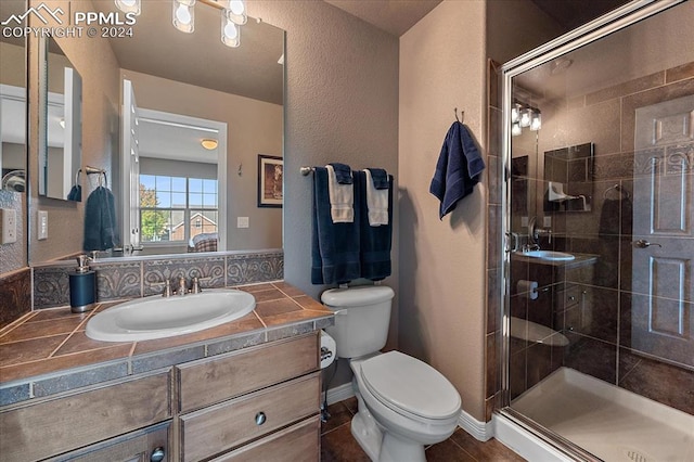 bathroom with a shower with door, tile patterned floors, vanity, and toilet