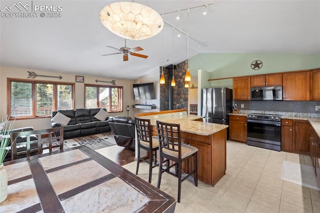 10760 Hardy Rd, Colorado Springs, CO 80908 - kitchen featuring brown cabinetry, track lighting, pendant lighting, lofted ceiling, and appliances with stainless steel finishes