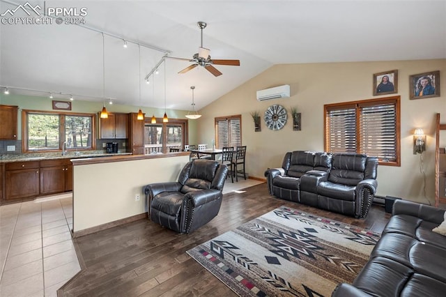 10760 Hardy Rd, Colorado Springs, CO 80908 - living area with a wall mounted air conditioner, vaulted ceiling, light wood-type flooring, track lighting, and ceiling fan