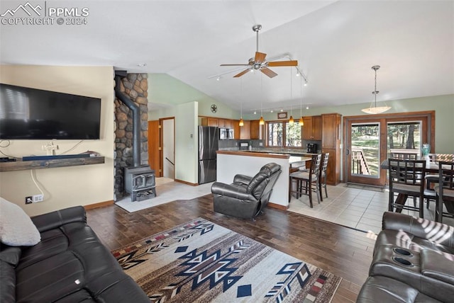 10760 Hardy Rd, Colorado Springs, CO 80908 - living area with lofted ceiling, ceiling fan, light wood-style flooring, and a wood stove