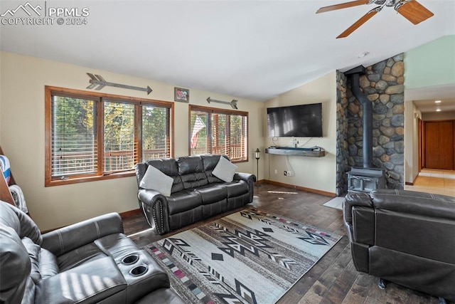 10760 Hardy Rd, Colorado Springs, CO 80908 - living room with vaulted ceiling, a wood stove, wood finished floors, baseboards, and ceiling fan
