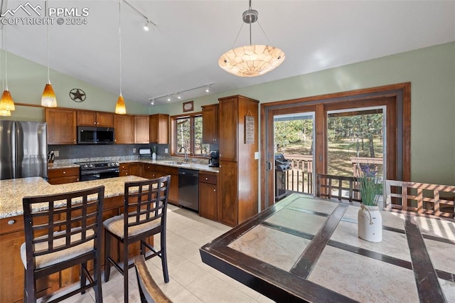10760 Hardy Rd, Colorado Springs, CO 80908 - kitchen with stainless steel appliances, rail lighting, a sink, decorative backsplash, and brown cabinetry