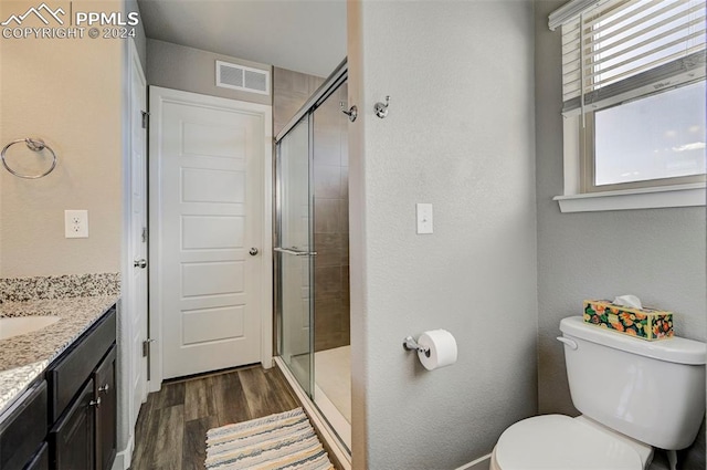 bathroom with vanity, toilet, hardwood / wood-style flooring, and an enclosed shower