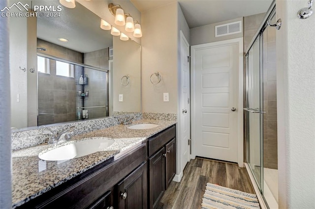 bathroom featuring vanity, hardwood / wood-style flooring, and a shower with shower door