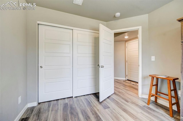 unfurnished bedroom with light hardwood / wood-style floors and a closet