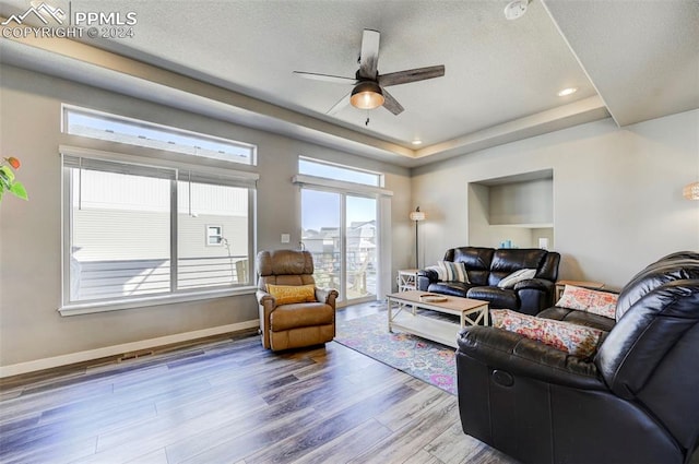 living room with hardwood / wood-style floors, a textured ceiling, and ceiling fan