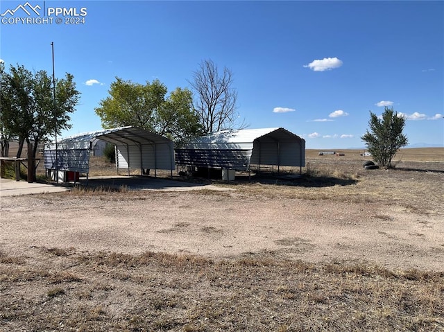 view of outdoor structure featuring a rural view and a carport