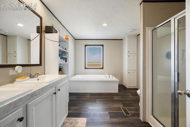 6652 Middlefield Ct, Colorado Springs, CO 80928 - bathroom with a garden tub, a shower stall, double vanity, wood finished floors, and recessed lighting