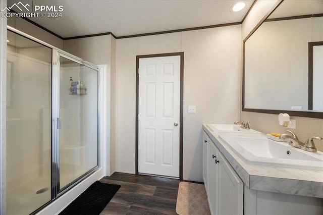 6652 Middlefield Ct, Colorado Springs, CO 80928 - bathroom with wood finished floors, a shower stall, ornamental molding, and double vanity