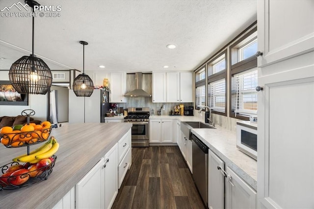 6652 Middlefield Ct, Colorado Springs, CO 80928 - kitchen with stainless steel appliances, wall chimney range hood, dark wood finished floors, light countertops, and white cabinets