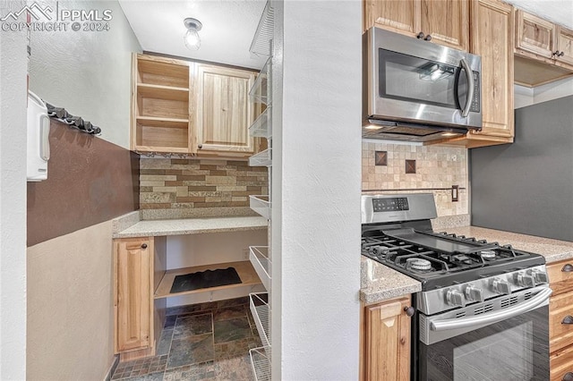 kitchen with light stone countertops, light brown cabinets, stainless steel appliances, and tasteful backsplash