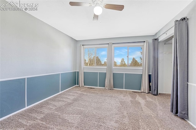 carpeted empty room featuring ceiling fan