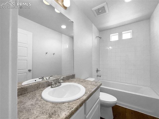 full bathroom featuring vanity, toilet, and tiled shower / bath combo