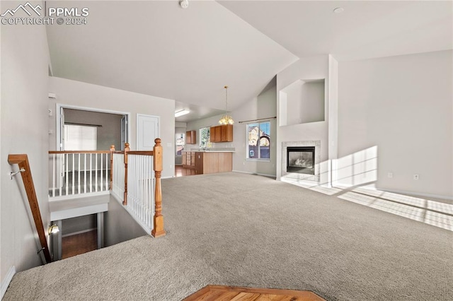 unfurnished living room featuring lofted ceiling and carpet