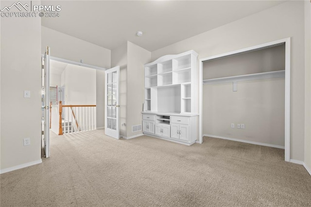 unfurnished bedroom featuring a closet and light carpet