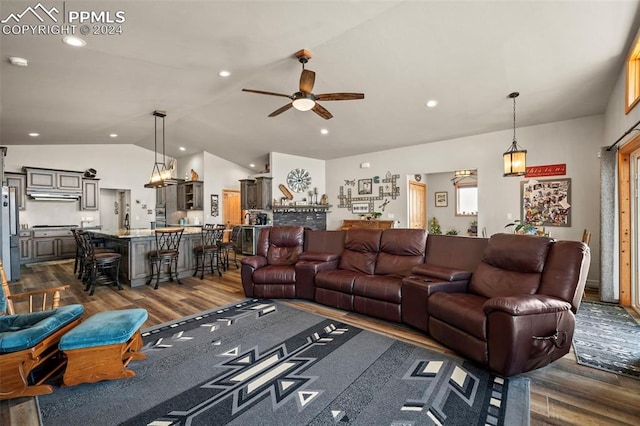 living room featuring dark hardwood / wood-style floors, vaulted ceiling, and ceiling fan