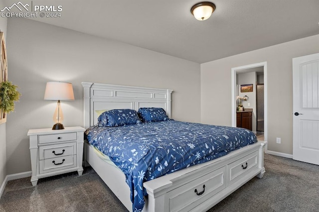 bedroom with ensuite bath and dark colored carpet