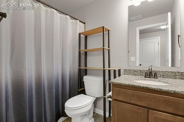 bathroom with walk in shower, vanity, and toilet