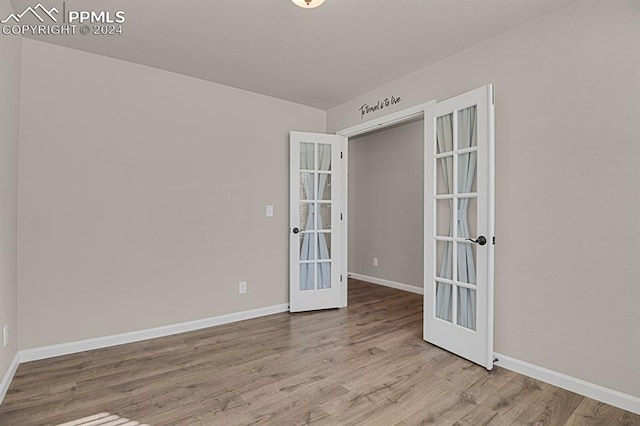 empty room with french doors and light wood-type flooring