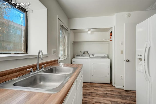 washroom with independent washer and dryer, sink, dark wood-type flooring, and plenty of natural light