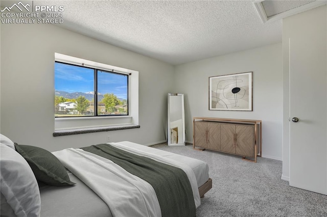 bedroom with light carpet and a textured ceiling