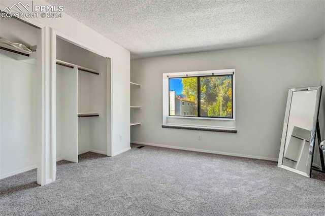 unfurnished bedroom with light carpet and a textured ceiling