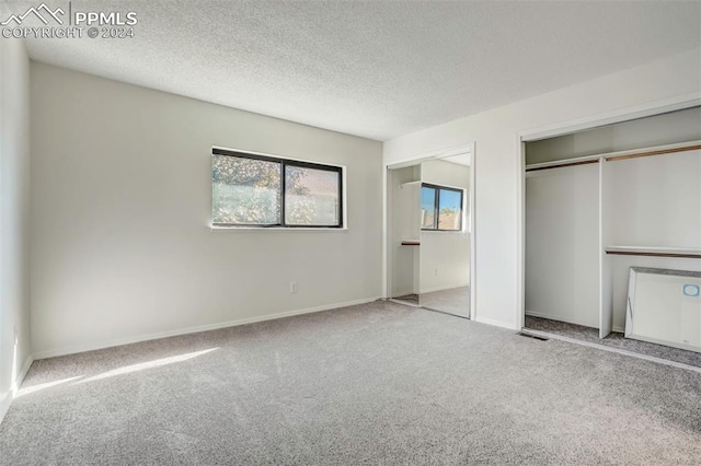 unfurnished bedroom with light carpet and a textured ceiling