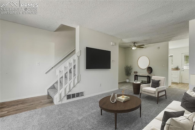 living room featuring a textured ceiling, wood-type flooring, and ceiling fan