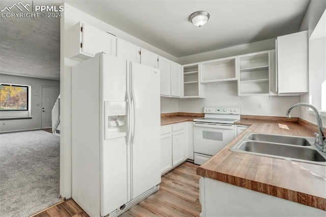 kitchen featuring white appliances, sink, butcher block counters, white cabinetry, and light hardwood / wood-style flooring