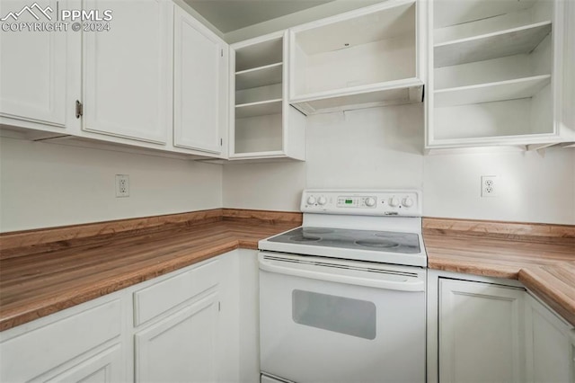 kitchen featuring white range with electric stovetop, butcher block countertops, and white cabinetry