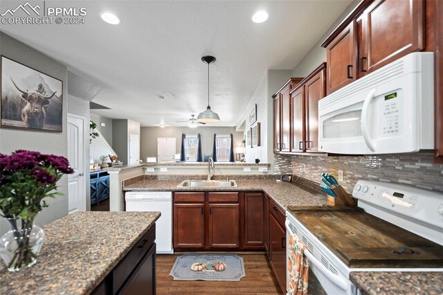 kitchen with tasteful backsplash, white appliances, a sink, and open floor plan