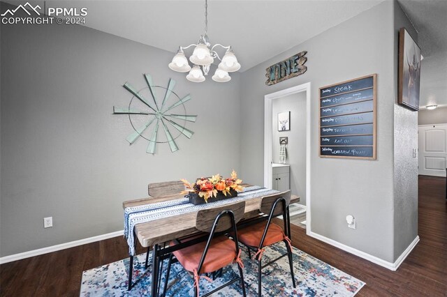 dining room featuring a chandelier, baseboards, and wood finished floors