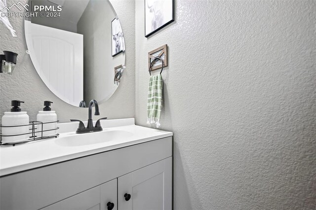 bathroom with vanity and a textured wall