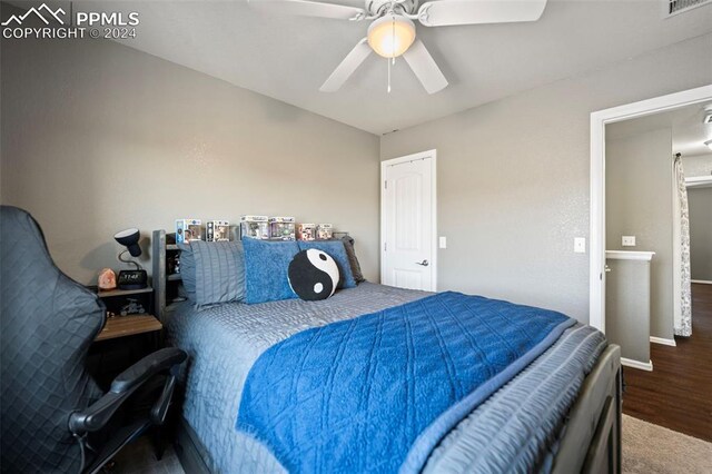 bedroom with baseboards, visible vents, a ceiling fan, and wood finished floors