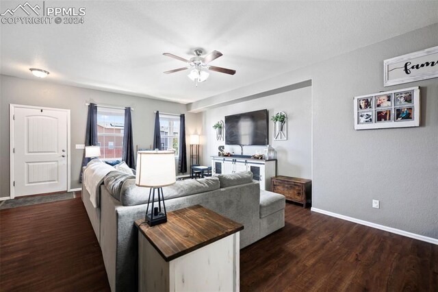 living room with dark wood-type flooring, baseboards, and a ceiling fan