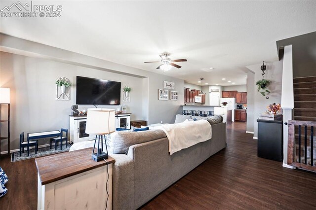 living room featuring dark wood-style flooring, recessed lighting, ceiling fan, baseboards, and stairs