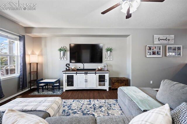 living room with ceiling fan, dark wood finished floors, and baseboards