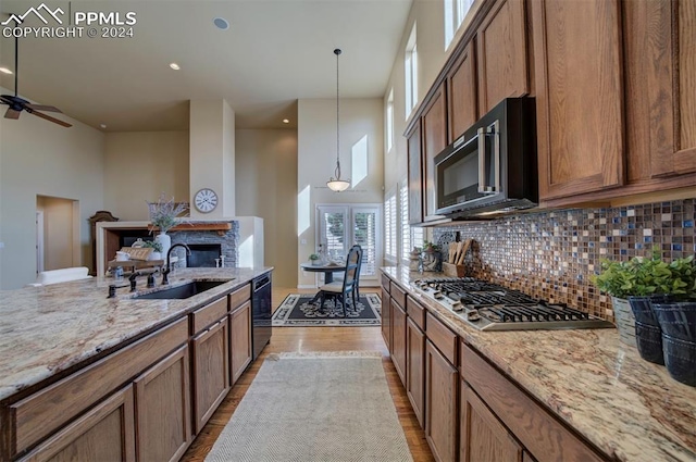 kitchen with decorative light fixtures, sink, a towering ceiling, and black appliances