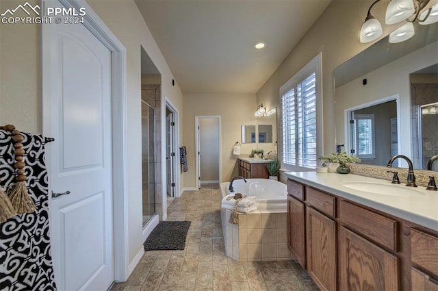 bathroom featuring vanity and independent shower and bath