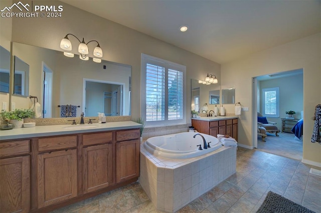 bathroom featuring tiled bath and vanity