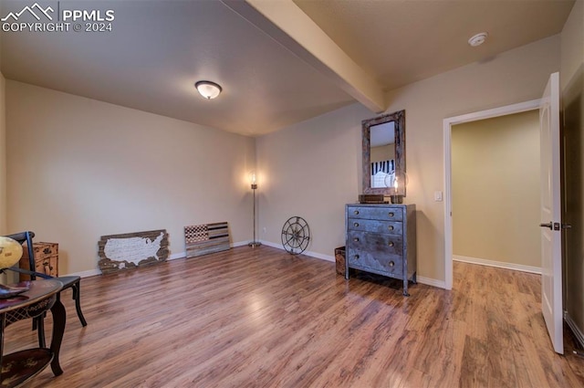 sitting room with hardwood / wood-style floors and beam ceiling