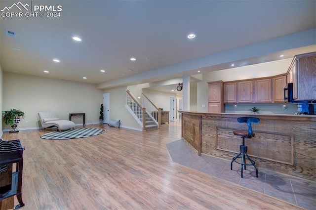 kitchen featuring light hardwood / wood-style floors, a breakfast bar, and kitchen peninsula