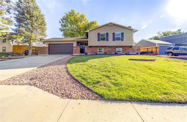 tri-level home with a garage and a front lawn